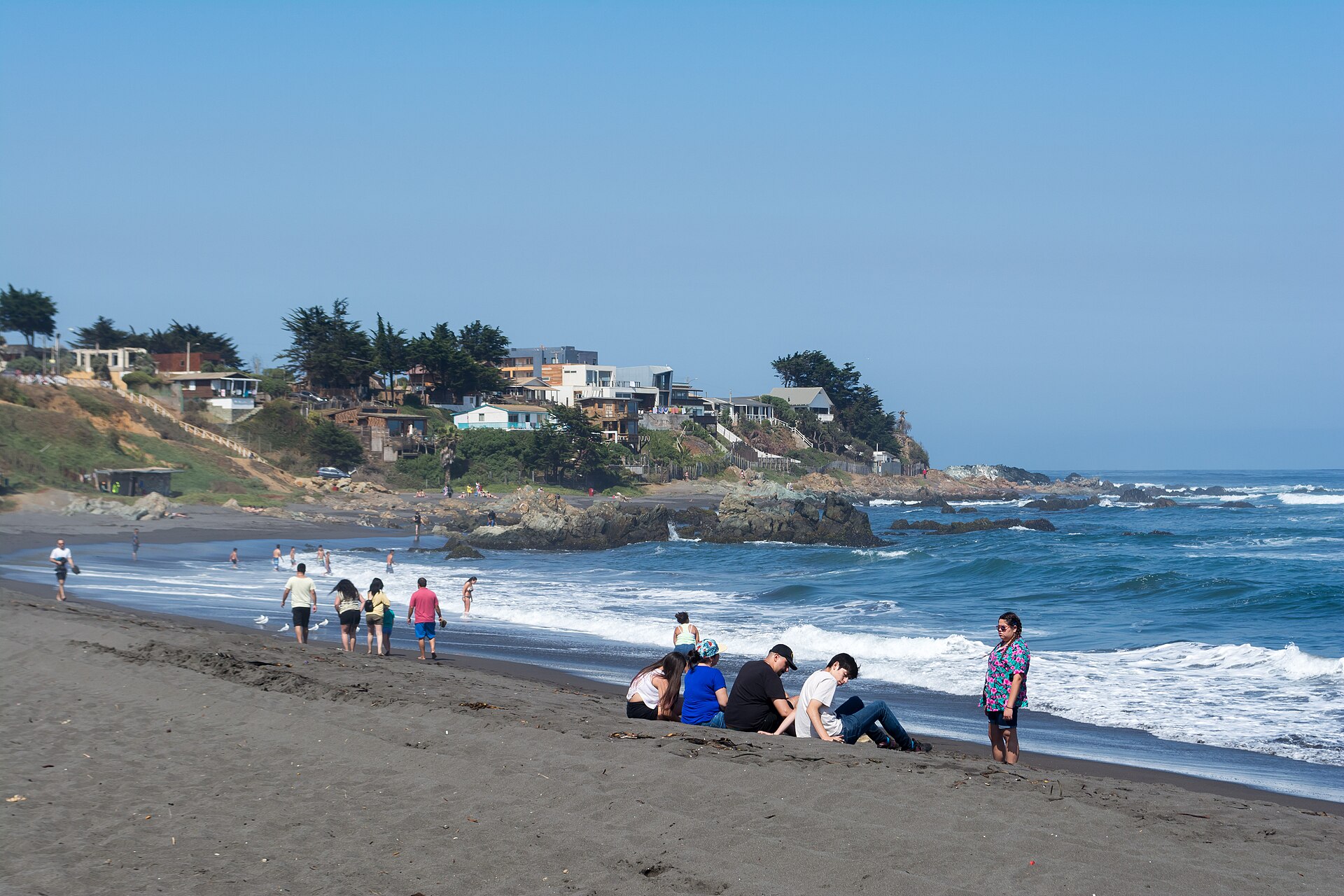 Playa Infiernillo, con su arena oscura, roqueríos y mar azul